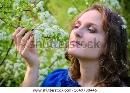 A woman with a branch of a flowering tree in her hands