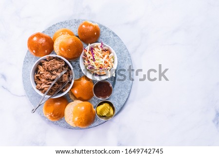 BBQ pulled pork sandwich in shape of small sliders with brioche buns.