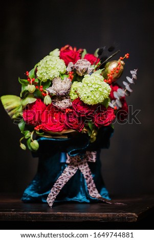 Beautiful bouquet of red roses, hydrangea and dried flowers on a dark background