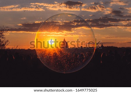 St. Peter's Basilica in a soap bubble during a beautiful red sunset in Rome - view from Villa Borghese, popular place among tourists