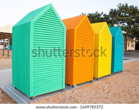 photo of a row of colored wooden small houses on beach