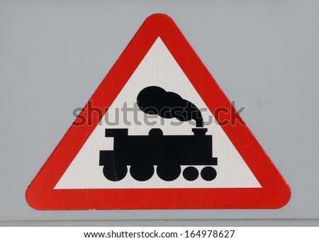 Danger, railway crossing roadsign with an illustration of a steam locomotive.