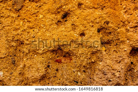 Surface of stone rock as grungy scratchy grainy texture yellow background toned in warm colors