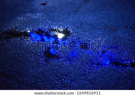 Puddle on the pavement with a blue light