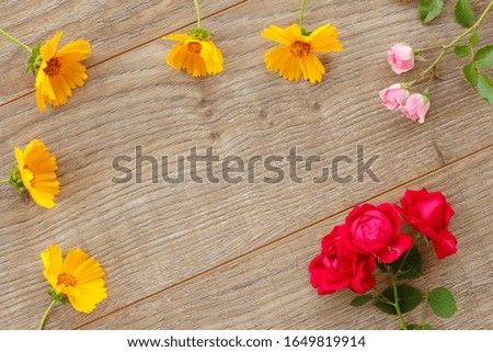 Beautiful roses and calendula flowers on the wooden background. Concept of giving a gift on holidays. Top view.