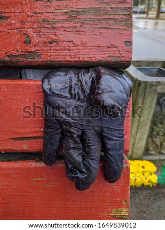 black glove thrown on a bench in rainy time