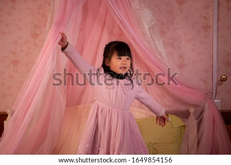 A lovely little girl posing for a picture in bed