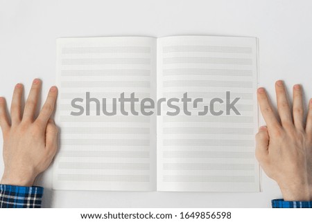 a view from above, person taking down the notes in notebook, empty blank paper mockup with copy space