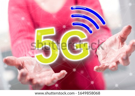 5g concept above the hands of a woman in background