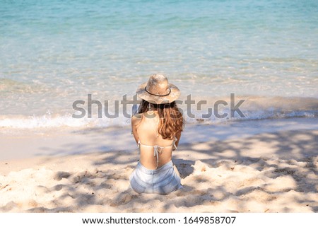Asian girl is reading a booking on the beach