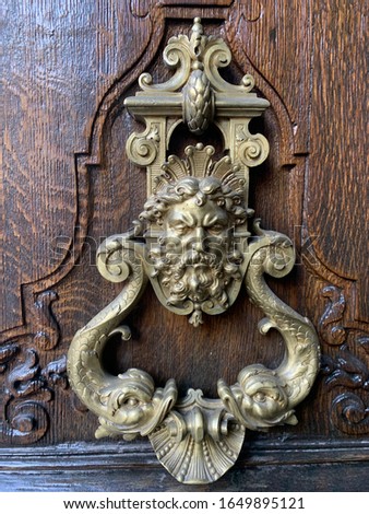 Old door handle in the shape of a bearded man’s head. 