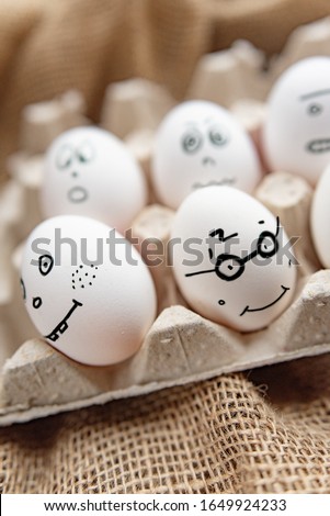 Emotional chicken eggs in a tray. Differnt  grimaces drawn on chicken eggs.