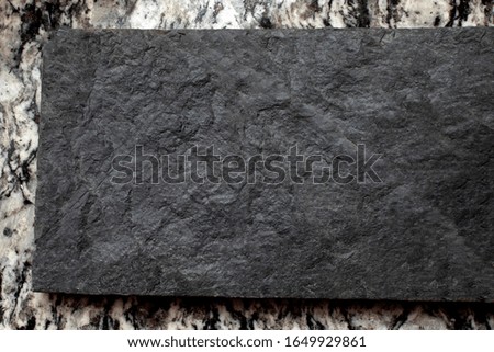 The background image of black stone rests on marble