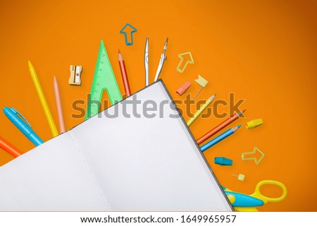 School notebook and colored stationery over table.