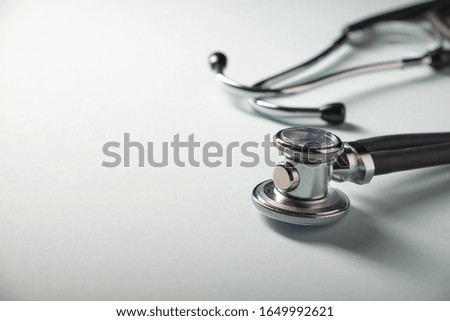 Side view of a medical stethoscope on a blue background