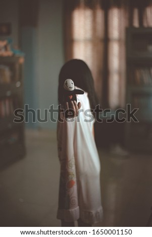 Abstract image of girl holding a doll, this picture tells about a ghost that linger around