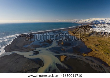 Aerial view of patterns of Icelandic rivers flowing into the ocean. Iceland in early spring