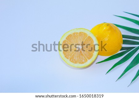 Summer and fresh image of a yellow lemon in the foreground