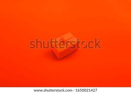 Gift box in an orange colour background, minimalism design, idea, conceptual images.