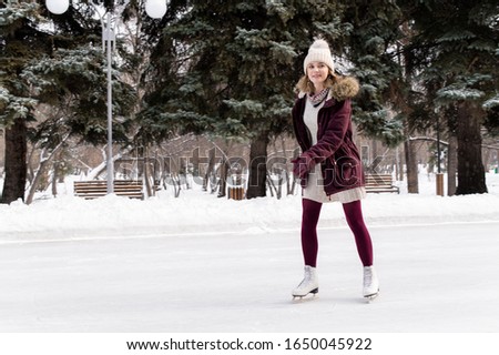 Young blonde caucasian girl having fun in winter park. Winter holidays concept