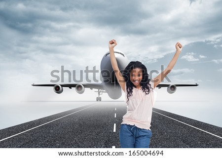 Composite image of a happy young woman is standing with her hands in the air