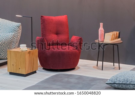 Red armchair wooden table with lamp, small coffee table in the interior. Royalty-Free Stock Photo #1650048820