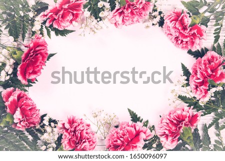 Round Frame Wreath with Carnation Flowers. Design concept for mothers day, wedding and valentines day with copy space. Aged photo. Retro style postcard. Selective focus.