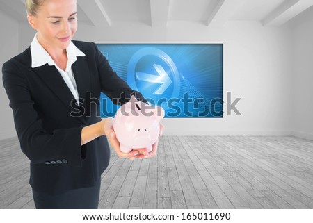 Composite image of blonde usinesswoman holding piggy bank