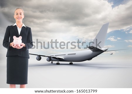 Composite image of blonde businesswoman holding pink piggy bank