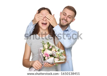 Happy young couple with bouquet of flowers on white background