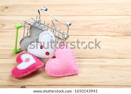 Fabric hearts with shopping cart on brown wooden table