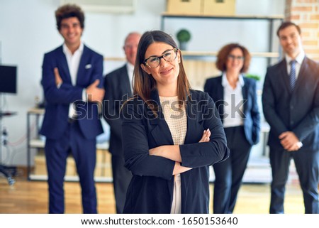 Group of business workers smiling happy and confident in a meeting. Standing with smile on face looking at camera at the office.