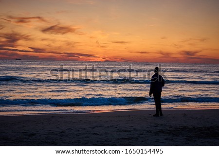 man at the beach in front of the sunset