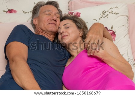 Loving Mature Couple in Bed Relaxing