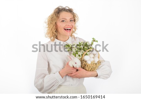 Spring holiday. Smiling woman holds basket with eggs and Easter bunny rabbit. Basket with eggs. Easter egg. Bunny. Happy Easter day. Cute furry rabbit. Tradition of Easter. Religion symbol. Eggs hunt.