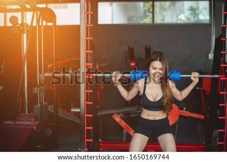 Women wearing black exercise clothes in the background have exercise equipment