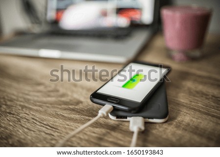 Charging mobile phone with power bank with charging mark on the screen