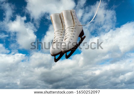 Collage, A pair of figure skates against a blue sky with white clouds