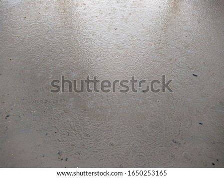 raindrops dripping in a brown puddle in the daytime