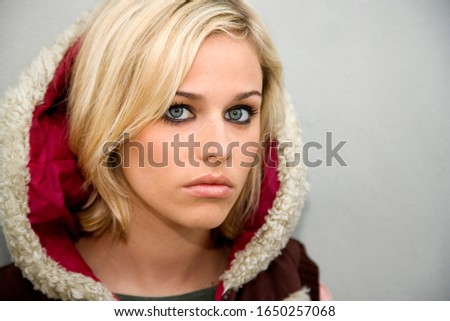 A teenage girl in a fur hooded jacket