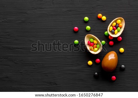 Delicious chocolate Easter bunny and eggs. Black stone background top view,flat lay, mockup