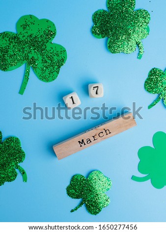St. Patrick's Day concept. Shamrocks and date of 17 March on wooden calendar on blue background.