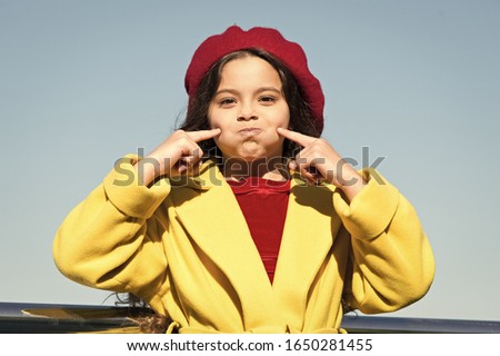 Silent as fish. Aint gonna say any word. Small girl wear fall outfit outdoors. Autumn secrets. Farewell to autumn. Last autumn beams. Idea for autumn leisure. Smiling little kid in hat sky background.