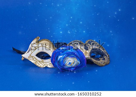 Black and white with golden glitter Carnivale masquerade mask on blue background with copy space. Carnival Mardi Gras day party bright festive decor. Invitation, banner, card, poster, flyer