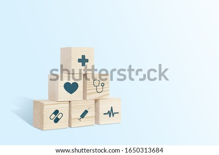 Medical symbols on wooden blocks. Medical and pharmaceutical concept. Medical treatment and public health problems. Signs from medicine on a light background.