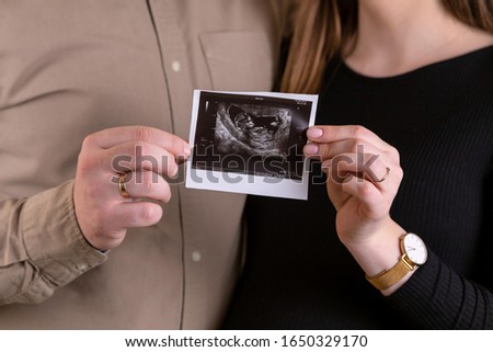 Pregnancy, pregnant woman, holding small shoot, waiting for a child, black dress, pregnant, waiting for a miracle, picture of a pregnant girl, snapshot of pregnancy, the expectation of a child. Royalty-Free Stock Photo #1650329170