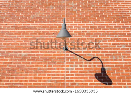 Isolated exterior wall design lighting. Brick wall with exterior halogen lamp. Decorative curved exterior wall lighting. 