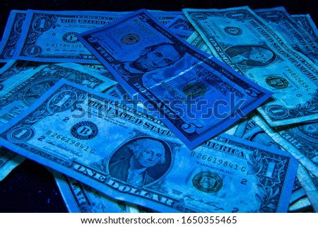 1. 5 dollars - United States paper currency under UV light. Verifying the authenticity.