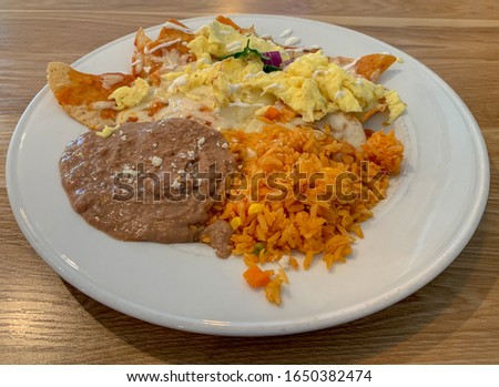 Red chilaquiles with scrambled eggs, refried beans and Spanish rice.