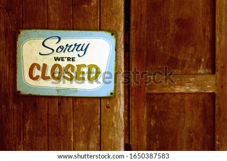 Retro rusty vintage metal closed sign on wooden brown shop window